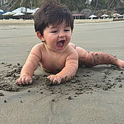 Joshua joined the competition — help win amazing prizes! baby, child, beach, sand, tropical, palm_trees, resort, outdoor, crawling, sitting, yawning, smiling, happy, portrait, barefoot, infant, shoreline, umbrellas, vacation, sunlight
