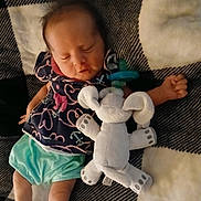 Presley is registered to the contest to win money with this photo: baby, sleeping, plush_toy, pacifier, blanket, infant, clothing, cute, patterned_outfit, lying_down, cozy, soft_toy, small_child, indoors, resting, peaceful, child, fabric, nap, comfort
