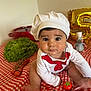 Reven participe au concours pour gagner de l'argent avec cette photo : baby, balloon, chef_hat, cherry_tomatoes, child, costume, cute, face, food, hands, indoor, kitchen, lettuce, person, playful, portrait, red_and_white, sitting, tablecloth, toy