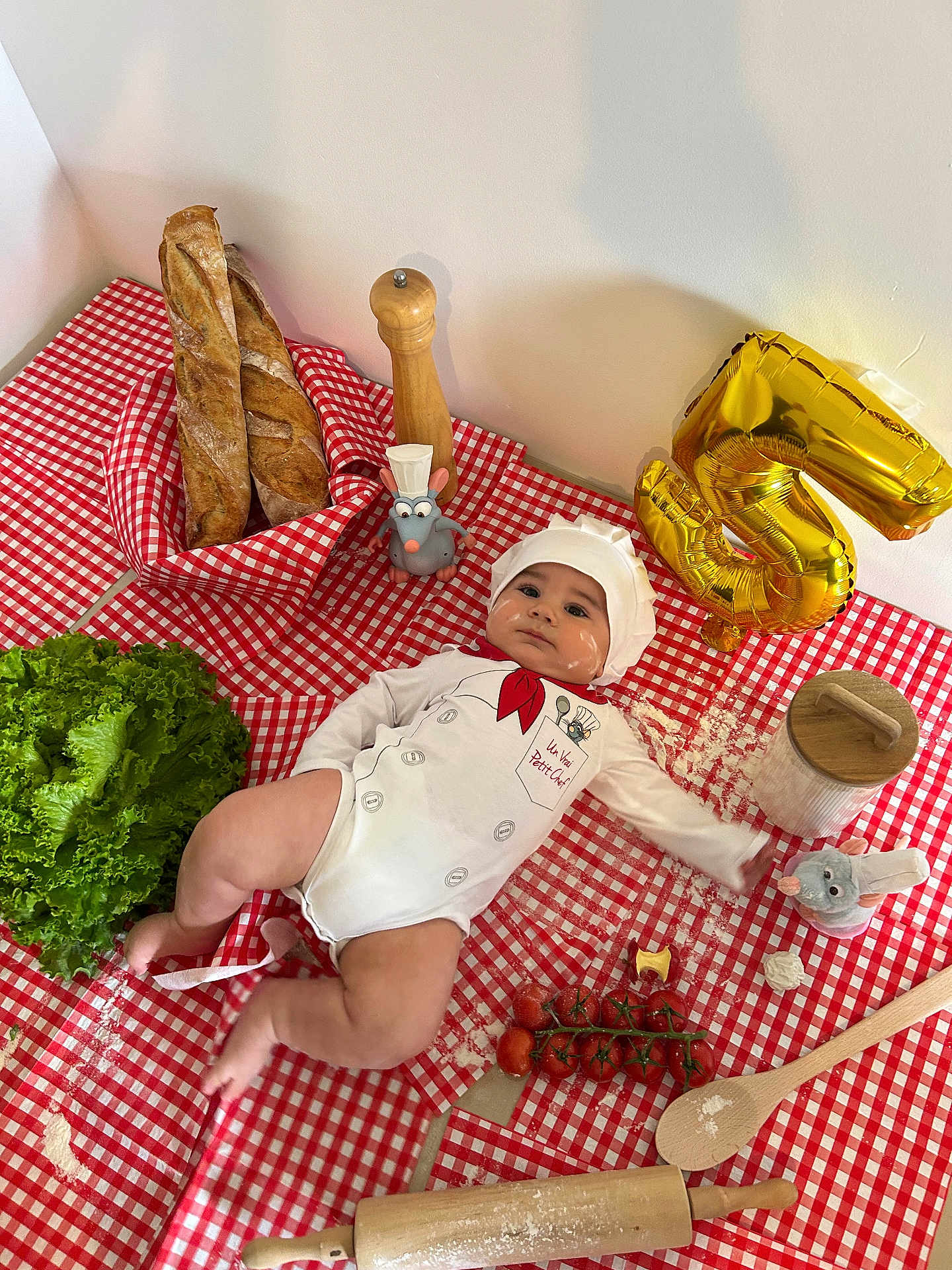 Reven participe au concours pour gagner de l'argent avec cette photo : baby, baguette, balloon, celebration, chef_costume, cherry_tomatoes, cooking, cute, floor, flour, food, infant, kitchen, lettuce, portrait, red_checkered, rolling_pin, tablecloth, toy_mouse, wooden_spoon