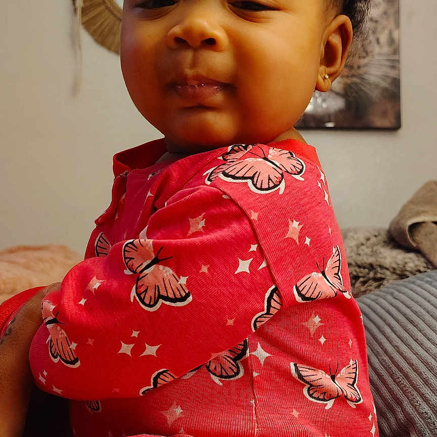 Camelle joined the competition — help win amazing prizes! baby, bed, blanket, butterfly_pattern, child, close_up, cozy, curly_hair, decor, earring, indoor, pajamas, person, pink_clothing, portrait, sleepy_expression, soft_texture, string_lights, toddler, wall_art