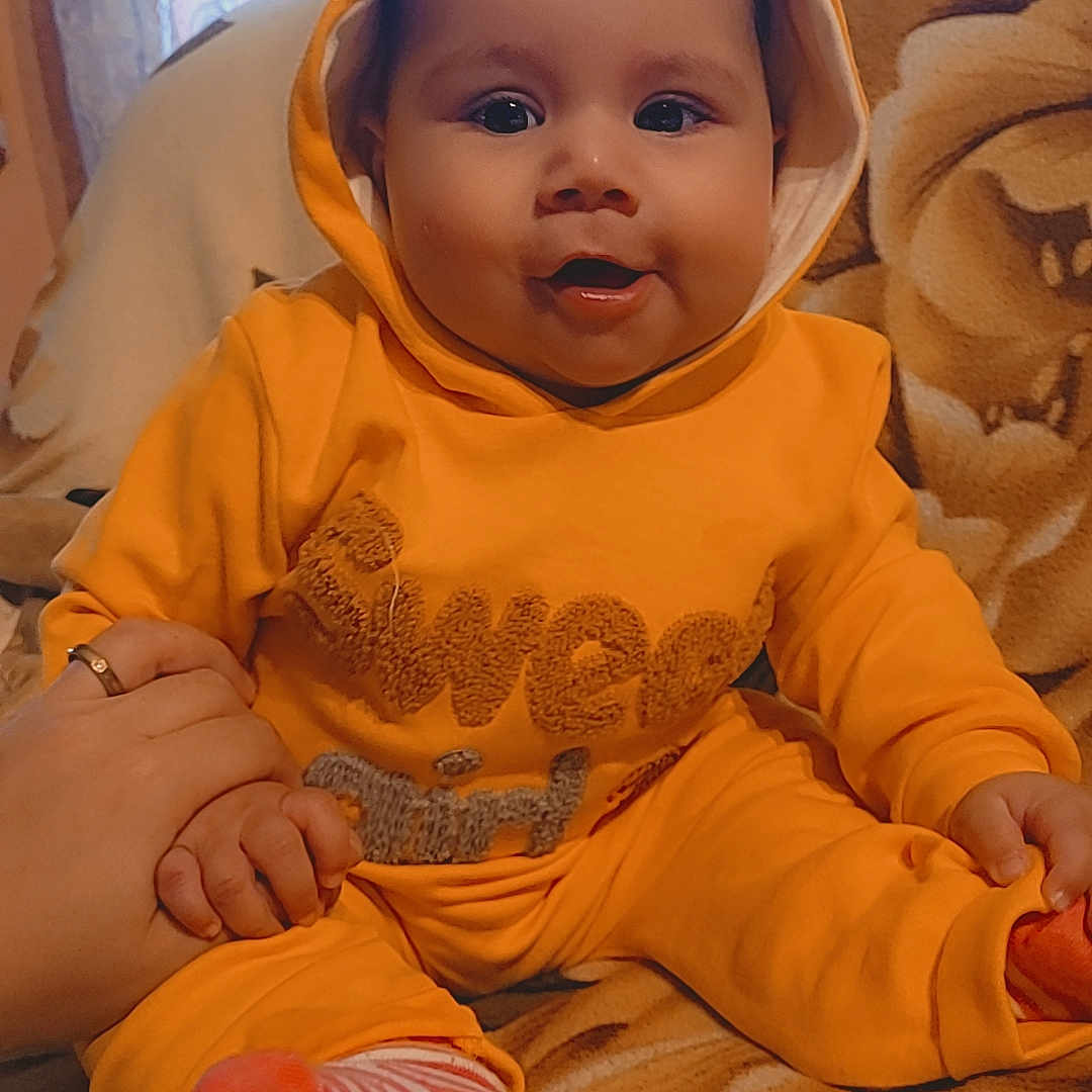 Aurora joined the competition — help win amazing prizes! baby, bodypart, bonnet, clothing, couch, face, finger, furniture, hand, hat, head, hood, hoodie, hosiery, knitwear, person, photography, portrait, sweater, sweatshirt