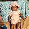 Majesti is registered to the contest to win money with this photo: baby, bed, blanket, casual, child, clothing, cute, fashion, hat, indoor, infant, looking, pattern, person, pillow, pink, portrait, relaxed, sitting, young