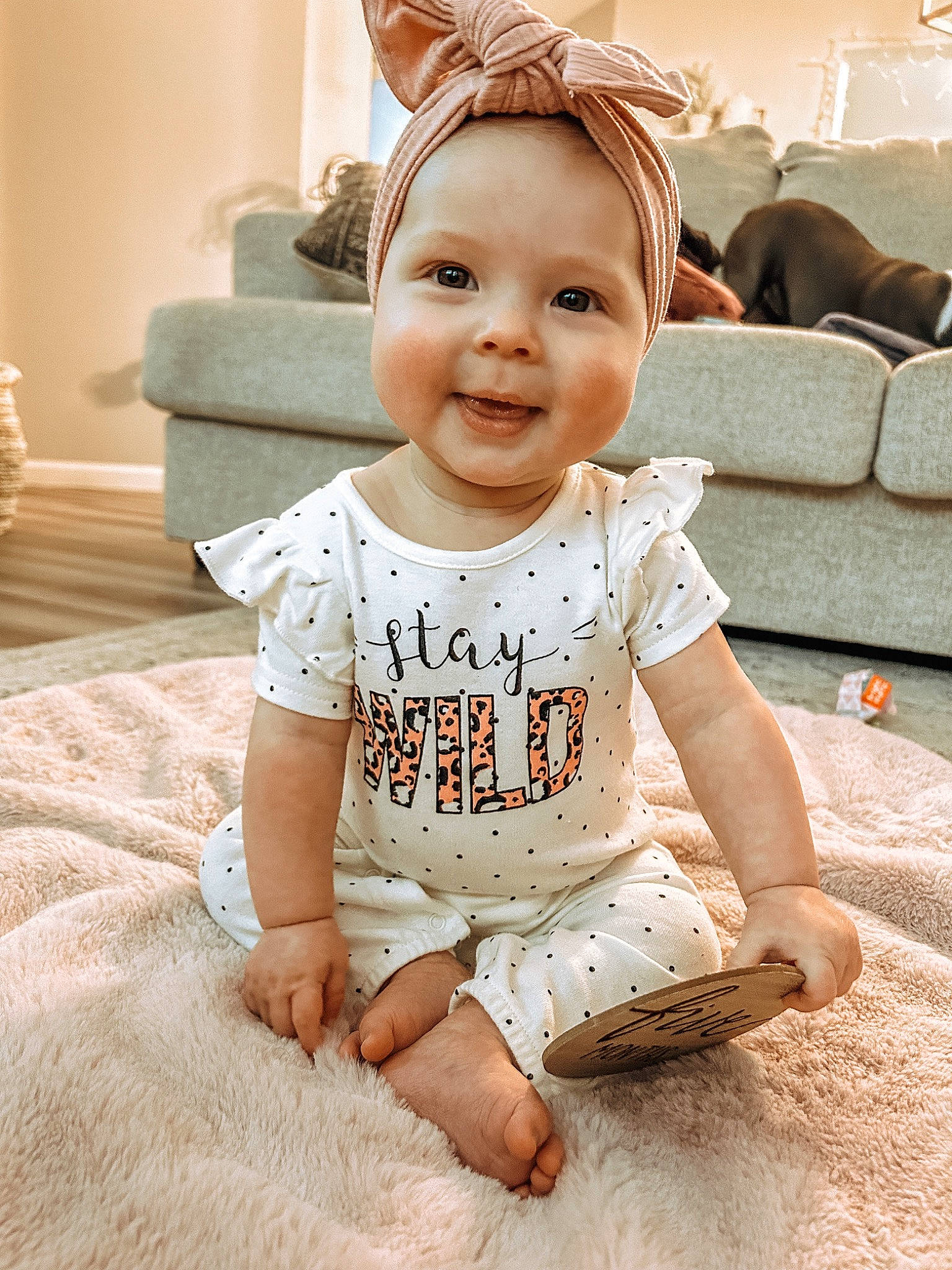 Stevi is registered to the contest to win money with this photo: baby, baby_toddler_clothing, cheek, child, comfort, eye, flash_photography, floor, flooring, happy, head, iris, pattern, person, sitting, skin, sleeve, smile, t_shirt, toddler
