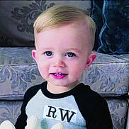 Mohammed joined the competition — help win amazing prizes! blonde_hair, blue_eyes, casual_clothing, child, couch, cozy, cute, face, furniture, happy, home, indoor, patterned_fabric, person, portrait, shirt, sitting, smiling, toddler, young_child