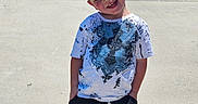 Kai is registered to the contest to win money with this photo: child, boy, smiling, outdoor, sunny_day, tshirt, shorts, red_shoes, concrete, sidewalk, hands_in_pockets, happy, casual_clothing, short_hair, portrait, standing, daylight, shadow, playful, young
