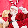 Sonny joined the competition — help win amazing prizes! dog, golden_retriever, santa_claus, christmas, holiday, red_background, candy_cane_antlers, glasses, white_beard, red_suit, white_gloves, bandana, kiss, pet, festive, smiling, cheerful, indoor, portrait, couch