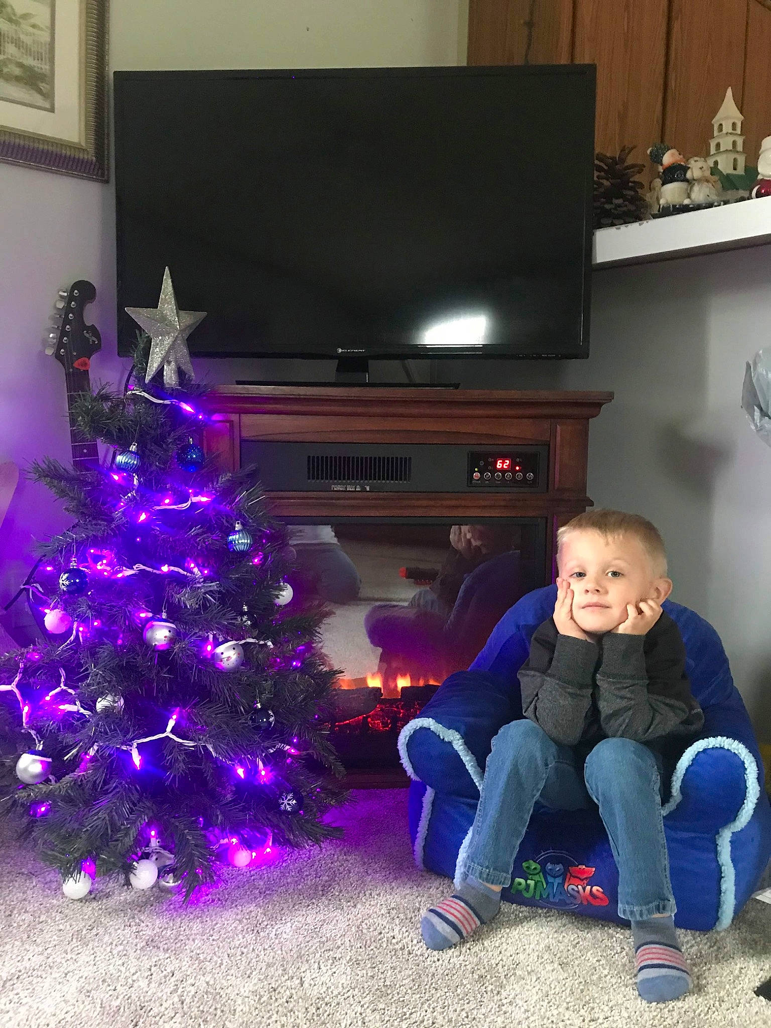 Scottie is registered to the contest to win money with this photo: christmas, christmas_decoration, christmas_eve, christmas_ornament, christmas_tree, event, fir, fun, holiday, interior_design, person, pine_family, plant, purple, room, toddler, tree, violet
