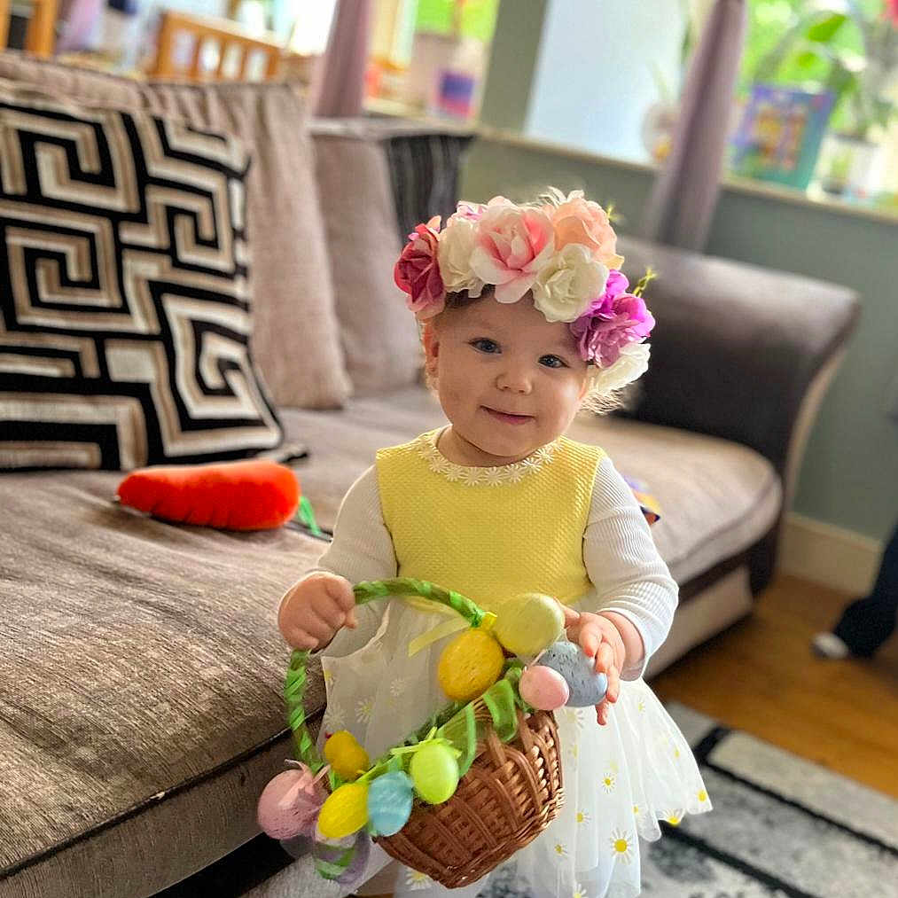 Iga is registered to the contest to win money with this photo: basket, carpet, child, couch, curtains, cute, decor, flower_crown, happy, home, indoor, living_room, pillow, smiling, toddler, toy_carrot, white_tights, window, wooden_floor, yellow_dress