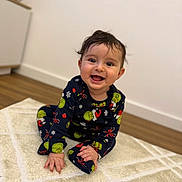Noah participe au concours pour gagner de l'argent avec cette photo : baby, child, smiling, pajamas, grinch, indoor, carpet, rug, floor, wooden_floor, happy, cute, toddler, clothing, person, portrait, sitting, face, hair, home