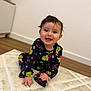 baby, child, smiling, pajamas, grinch, indoor, carpet, rug, floor, wooden_floor, happy, cute, toddler, clothing, person, portrait, sitting, face, hair, home
