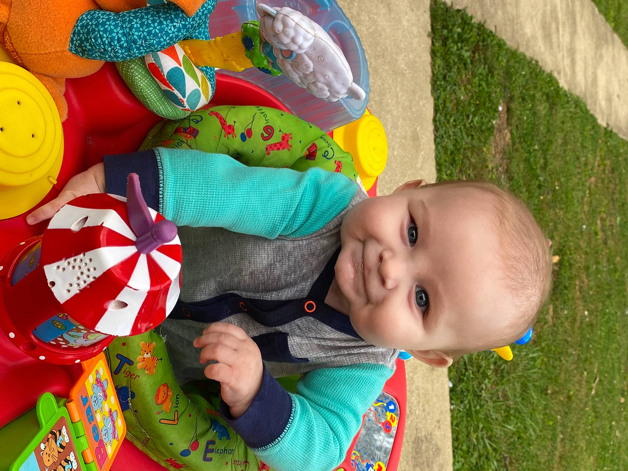 Rayder is registered to the contest to win money with this photo: baby, baby_toddler_clothing, cheek, child, event, facial_expression, fun, grass, green, happy, joy, leisure, pattern, people, people_in_nature, person, plant, play, product, smile