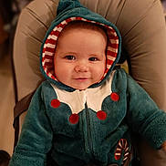 Ezra participe au concours pour gagner de l'argent avec cette photo : baby, child, smiling, hood, jacket, cozy, seated, infant, face, cute, red, white, teal, striped, candy_cane, clothing, indoor, portrait, young, person