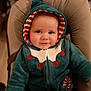 baby, child, smiling, hood, jacket, cozy, seated, infant, face, cute, red, white, teal, striped, candy_cane, clothing, indoor, portrait, young, person