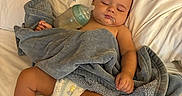 Bodie is registered to the contest to win money with this photo: baby, sleeping, blanket, bottle, milk, diaper, bed, pillow, infant, rest, cozy, peaceful, child, skin, hand, foot, nursery, cute, relaxation, indoors