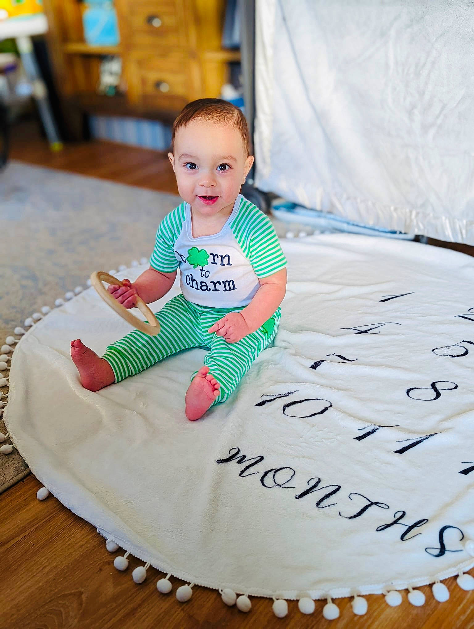 Bradley is registered to the contest to win money with this photo: baby, baby_toddler_clothing, dress, facial_expression, floor, flooring, fun, happy, hardwood, leisure, mammal, pattern, people, person, play, product, sleeve, t_shirt, textile, toddler