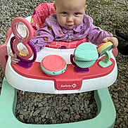 Lillyann joined the competition — help win amazing prizes! baby, child, walker, toy, outdoor, gravel, play, curious, mischievous, purple_clothing, seat, hands, face, head, footwear, plastic, colorful, infant, person, playtime