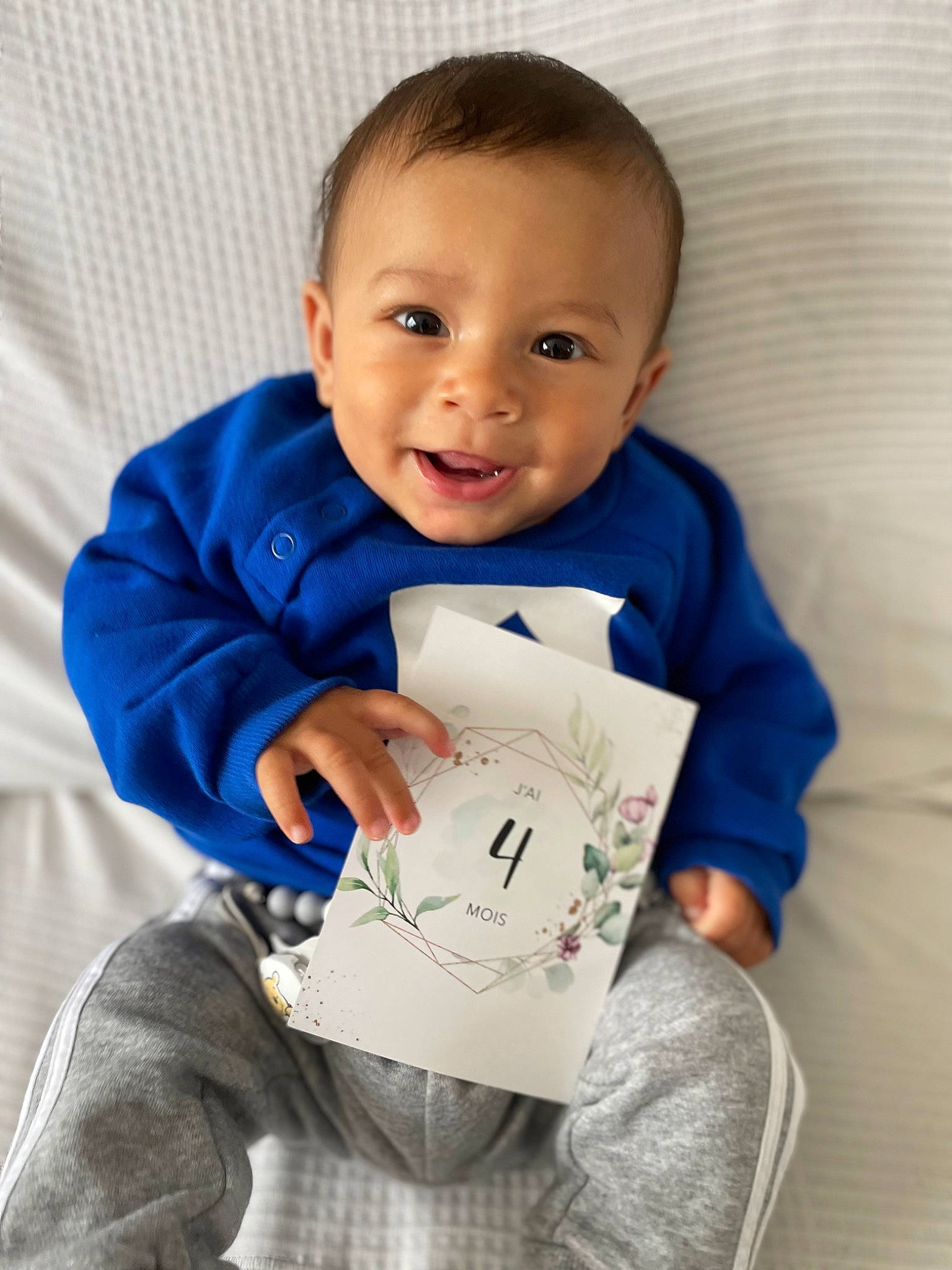 Louan participe au concours pour gagner de l'argent avec cette photo : baby, baby_products, baby_toddler_clothing, cheek, child, comfort, denim, electric_blue, finger, hair, happy, linens, person, product, room, sitting, sleeve, smile, sportswear, t_shirt