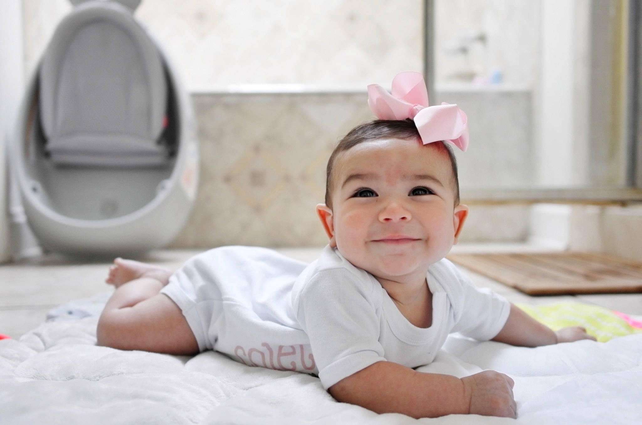 Colette is registered to the contest to win money with this photo: baby, baby_toddler_clothing, bedding, cap, child, comfort, fashion_accessory, flooring, fun, grass, hair_accessory, happy, joy, linens, person, portrait_photography, room, sitting, skin, sleeve