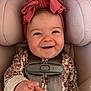 Stevie is registered to the contest to win money with this photo: baby, infant, car_seat, headband, bow, smile, hand, clothing, straps, seat_belt, portrait, cute, child, indoors, closeup, happy, young, person, face, expression