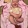 Stevie joined the competition — help win amazing prizes! baby, infant, smiling, headband, bow, blanket, basket, carpet, wooden_sign, flower_shape, clothing, happy, cute, sitting, hands, feet, indoor, skin, portrait, child