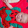 baby, infant, watermelon_outfit, red_blanket, decorative_sign, flowers, milestone, cute, lying_down, smiling, child, portrait, celebration, hand_up, clothing, baby_girl, face, skin, happy, resting