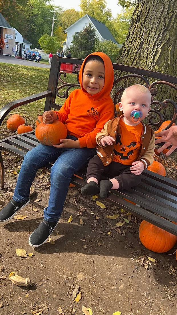 Caiden is registered to the contest to win money with this photo: boot, calabaza, chair, fun, gourd, grass, happy, headwear, joy, lap, leg, leisure, orange, person, plant, pumpkin, shoe, sitting, sneakers, toddler