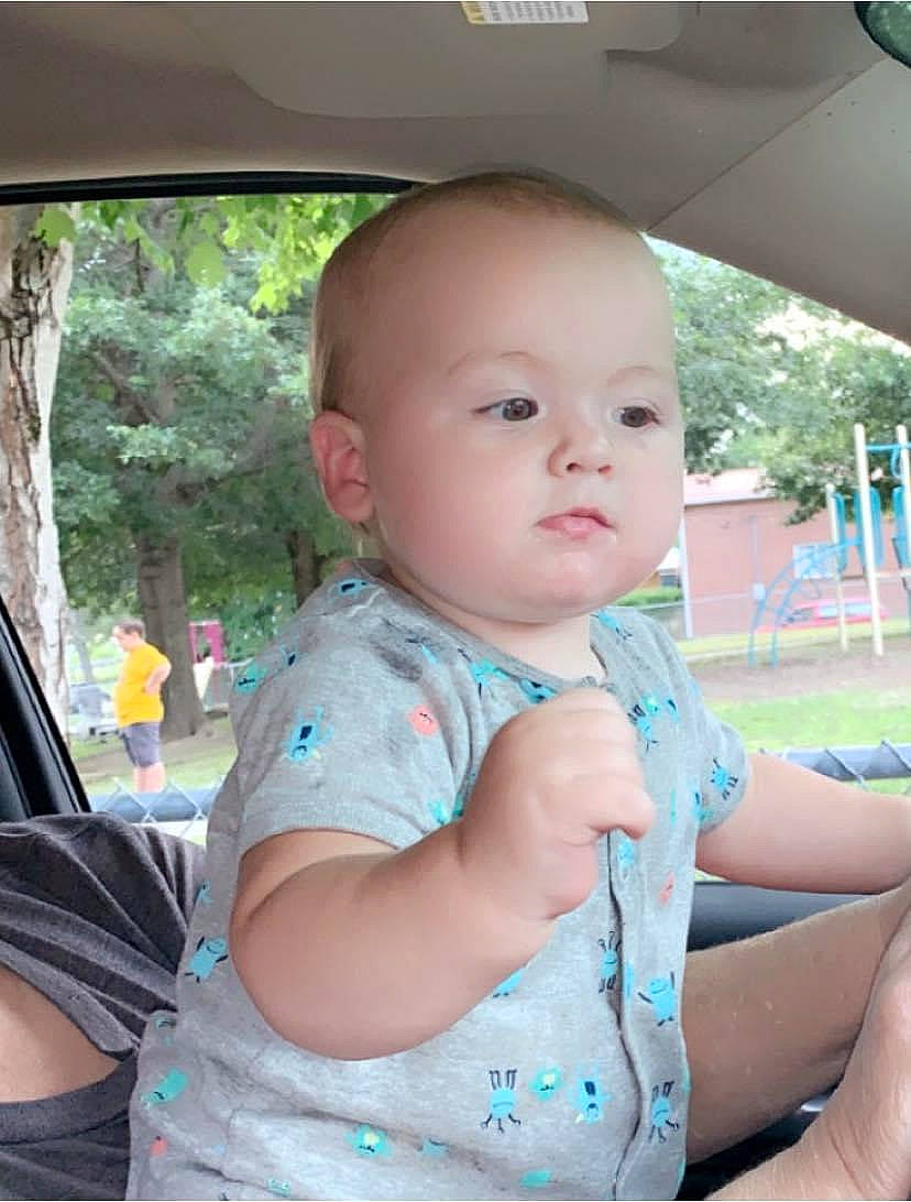 Clay is registered to the contest to win money with this photo: baby, baby_toddler_clothing, chin, facial_expression, finger, fun, grass, hairstyle, happy, human_body, leisure, motor_vehicle, mouth, person, pink, plant, skin, t_shirt, toddler, tree