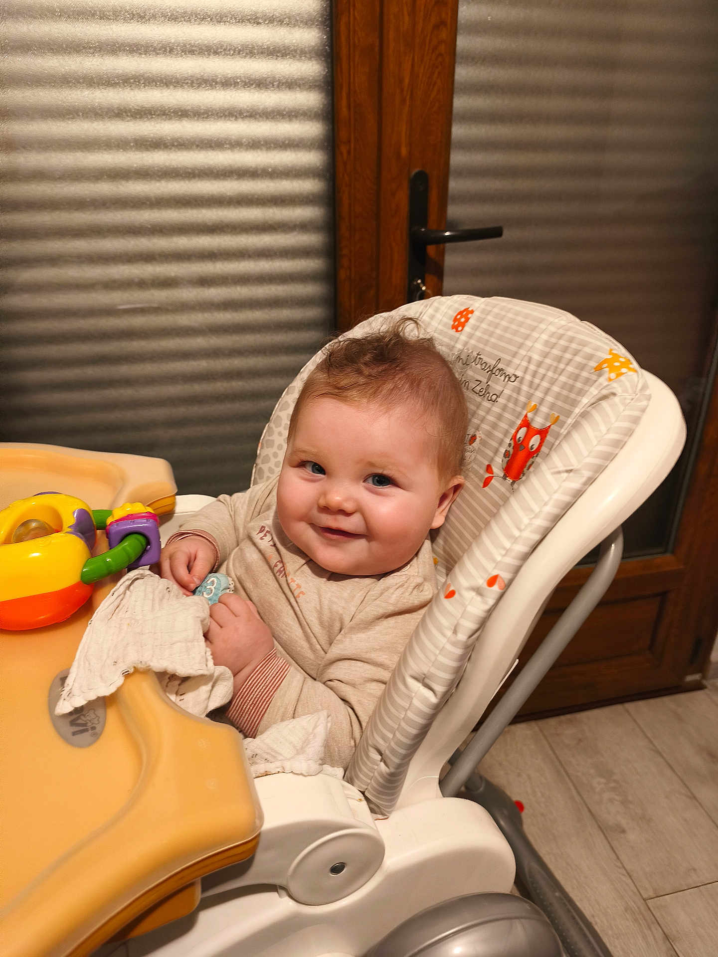 Loelya a rejoint le concours — aidez-le/la à gagner de superbes lots ! baby, high_chair, smile, toy, cloth, indoor, wooden_door, window, floor, face, child, person, cute, happy, furniture, infant, clothing, home, seat, curly_hair