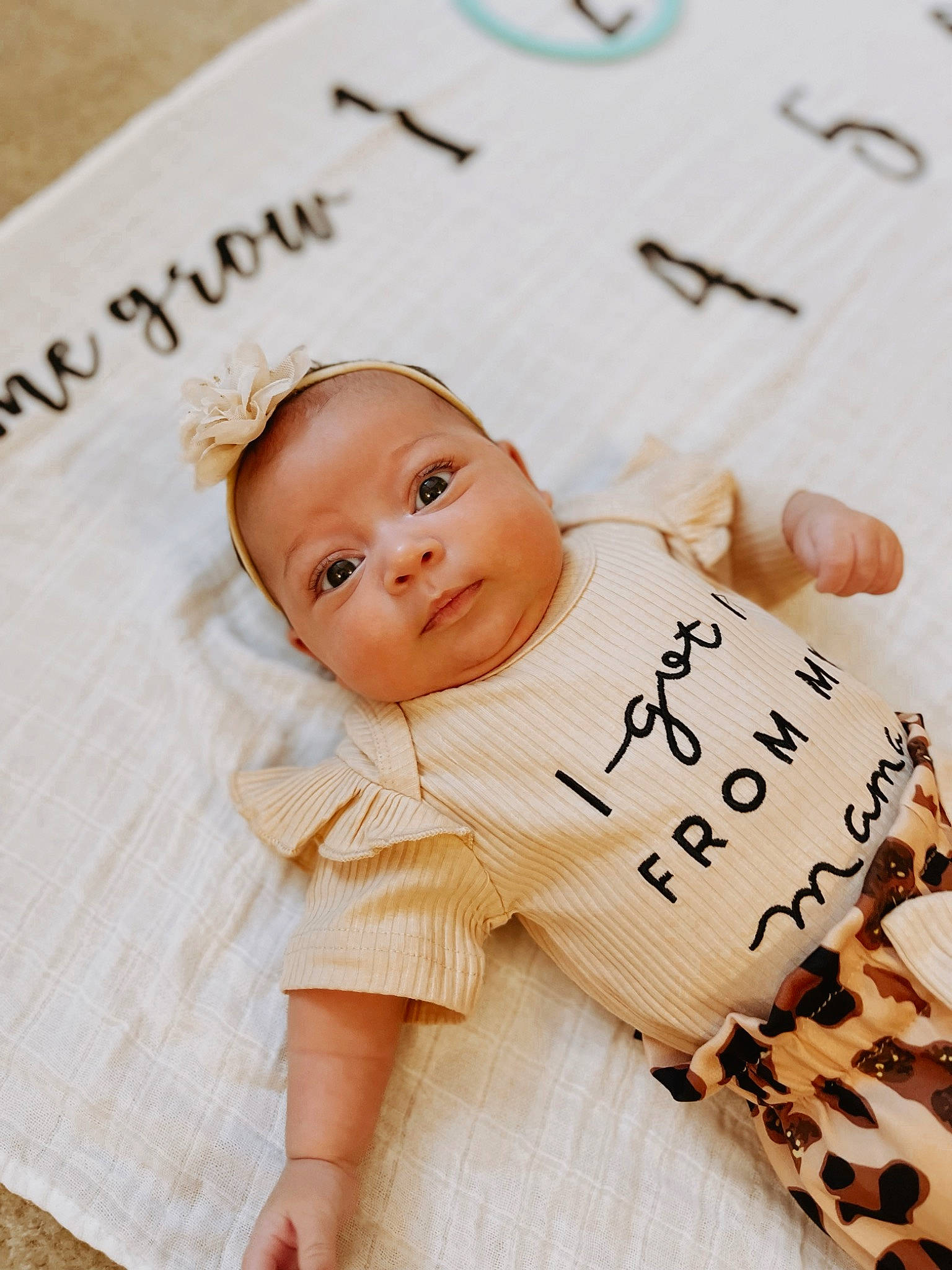 Mila is registered to the contest to win money with this photo: baby, baby_toddler_clothing, cheek, child, face, finger, font, happy, material_property, nail, paper_product, pattern, peach, person, product, skin, sleeve, smile, toddler, white