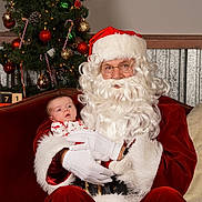 Catherine joined the competition — help win amazing prizes! baby, beard, candy_cane, celebration, christmas_ornaments, christmas_tree, cozy, decoration, festive, fur_trim, glasses, holiday, indoor, person, portrait, red_couch, santa_claus, smiling, white_gloves, winter