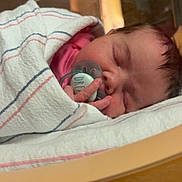 Catherine is registered to the contest to win money with this photo: newborn, baby, sleeping, pacifier, blanket, hospital, infant, wrapped, cozy, cute, child, face, peaceful, portrait, tiny, fingers, soft, resting, indoors, warm_lighting