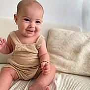 Naïm participe au concours pour gagner de l'argent avec cette photo : baby, smiling, infant, romper, couch, pillow, indoor, cute, child, sitting, happy, skin, foot, hand, bracelet, portrait, cozy, home, light, young