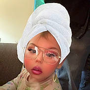 Echõ joined the competition — help win amazing prizes! toddler, child, glasses, towel_turban, makeup_filter, indoors, couch, onesie, frog_pattern, cupcake_pattern, curious, face, person, baby, clothing, sitting, portrait, eyewear, cute, filter