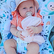 Ilona participe au concours pour gagner de l'argent avec cette photo : baby, child, pacifier, hat, plush_toy, bunny, seat, patterned_fabric, infant, clothing, cute, blue_eyes, barefoot, orange_shirt, bracelet, toy, baby_seat, indoor, comfort, person