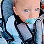 toddler, child, pacifier, blue_eyes, blonde_hair, stroller, seatbelt, outdoor, curious, casual_clothing, safety_harness, baby, portrait, daylight, young_child, close_up, soft_light, person, cute, infant