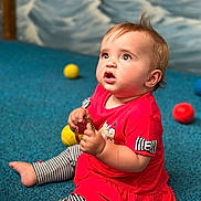 Giulia a rejoint le concours — aidez-le/la à gagner de superbes lots ! baby, child, sitting, red_dress, striped_leggings, bracelet, blue_carpet, yellow_ball, orange_ball, blue_ball, curious_expression, indoor, floor, person, cute, young_child, play, toy, portrait, casual_clothing