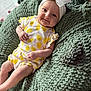 baby, infant, smile, headband, bow, yellow_clothing, white_clothing, knit_blanket, green_blanket, texture, cute, happy, indoors, child, person, portrait, sitting, cozy, soft, young