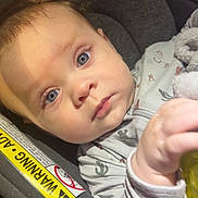 Waylon joined the competition — help win amazing prizes! baby, infant, blue_eyes, car_seat, onesie, child, hand, face, close_up, seat_belt_warning, soft_lighting, indoor, cute, young_child, expression, person, holding_object, hair, portrait, toddler