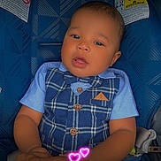 Dj Civils is registered to the contest to win money with this photo: baby, child, car_seat, blue_clothing, vest, bow_tie, holding_hands, infant, cute, portrait, seatbelt, plaid, buttoned_clothing, person, hand, love, neon_hearts, fashion, sitting, young