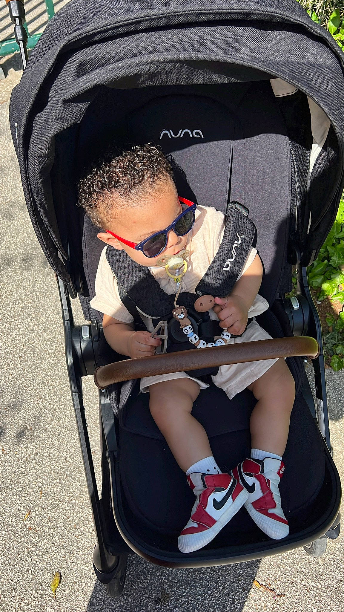 Emiliano a rejoint le concours — aidez-le/la à gagner de superbes lots ! baby_products, black, comfort, eyewear, fashion_accessory, fun, goggles, grass, hat, human_leg, knee, leisure, person, personal_protective_equipment, plant, recreation, shorts, sitting, sunglasses, vision_care