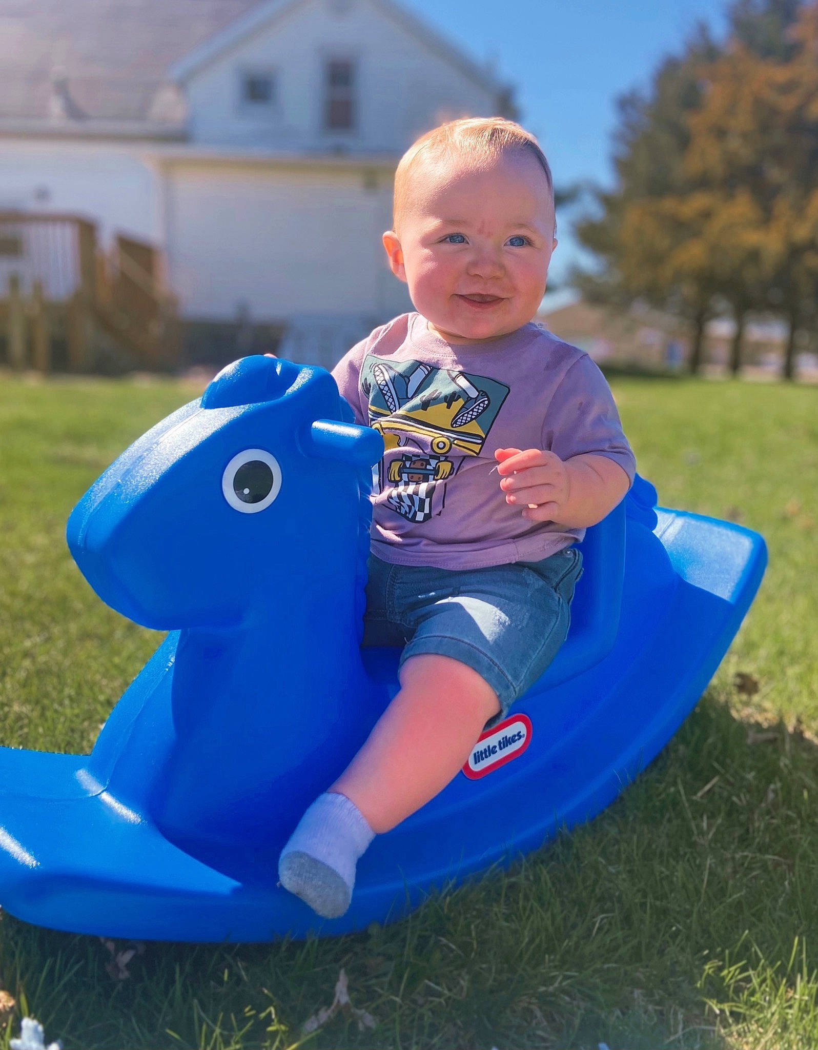 Levi is registered to the contest to win money with this photo: baby, baby_toddler_clothing, child, electric_blue, fun, grass, happy, lawn, leisure, outdoor_recreation, people_in_nature, person, plant, recreation, sitting, sky, smile, t_shirt, toddler, toy