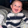 baby, child, smiling, happy, onesie, striped_clothing, sitting, blanket, indoor, portrait, cute, infant, face, eyes, hand, cozy, soft, warm, baby_clothes, young_child