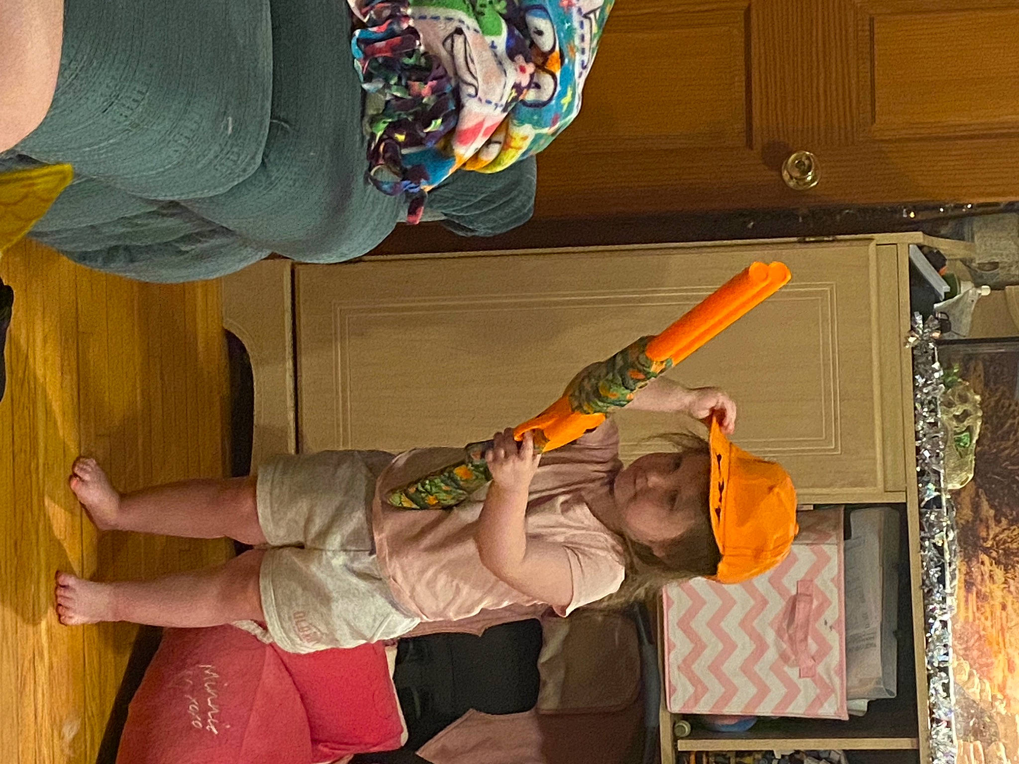 Kali is registered to the contest to win money with this photo: arm, cabinetry, elbow, fun, hardwood, hat, human_leg, knee, leg, musical_instrument, orange, peach, person, room, thigh, walking_shoe, wood, wrist