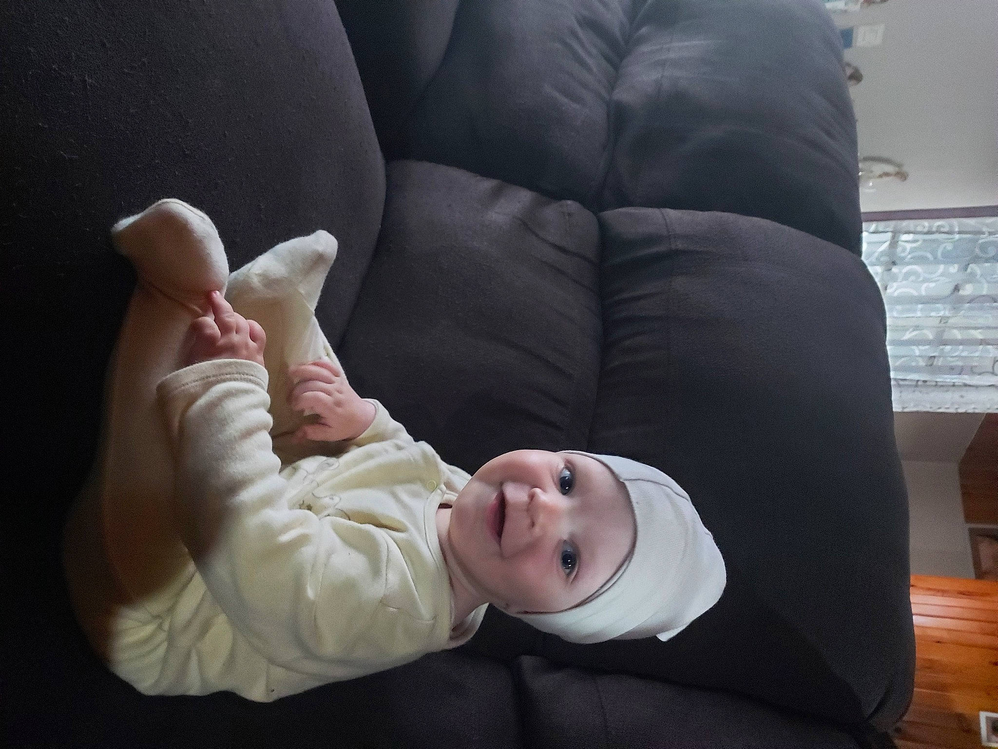 Uriel participe au concours pour gagner de l'argent avec cette photo : baby, baby_toddler_clothing, cheek, child, comfort, couch, eye, face, finger, flash_photography, gesture, head, headwear, human_body, person, sitting, skin, sleeve, smile, toddler