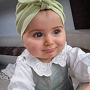 Nola participe au concours pour gagner de l'argent avec cette photo : baby, child, headwrap, green, bow, white, collar, lace, dress, portrait, cute, smile, indoor, person, face, young_child, long_eyelashes, hand, seated, curious