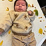 autumn, baby, blanket, child, clothing, corduroy_pants, cozy, cute, expressionless, face, head, indoor, infant, knitwear, lying_down, person, small_hand, soft_texture, sweater, yellow_leaves