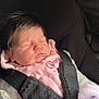 baby, sleeping, car_seat, infant, child, pink_bib, clothing, harness, seatbelt, cute, peaceful, newborn, portrait, indoor, soft_lighting, face, hair, child_safety, toddler, adorable
