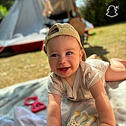 Mattéo participe au concours pour gagner de l'argent avec cette photo : baby, blanket, cap, child, clothing, cute, daylight, face, giraffe, grass, hands, happy, infant, outdoor, play, smiling, stroller, sunlight, tent, toy
