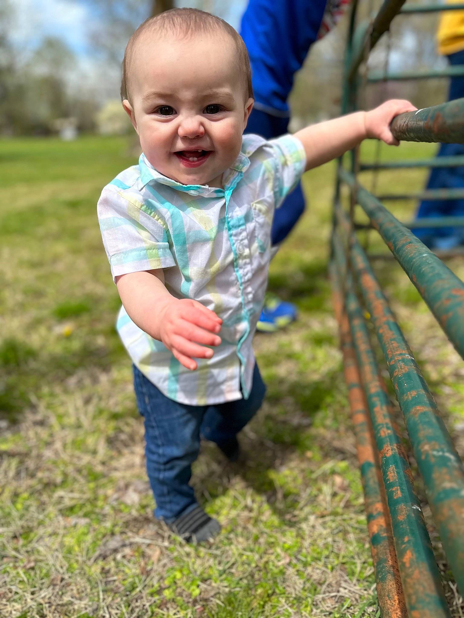 Nash is registered to the contest to win money with this photo: baby, baby_toddler_clothing, child, city, face, fence, fun, grass, grassland, happy, joy, leisure, people_in_nature, person, recreation, sitting, sleeve, smile, soil, t_shirt